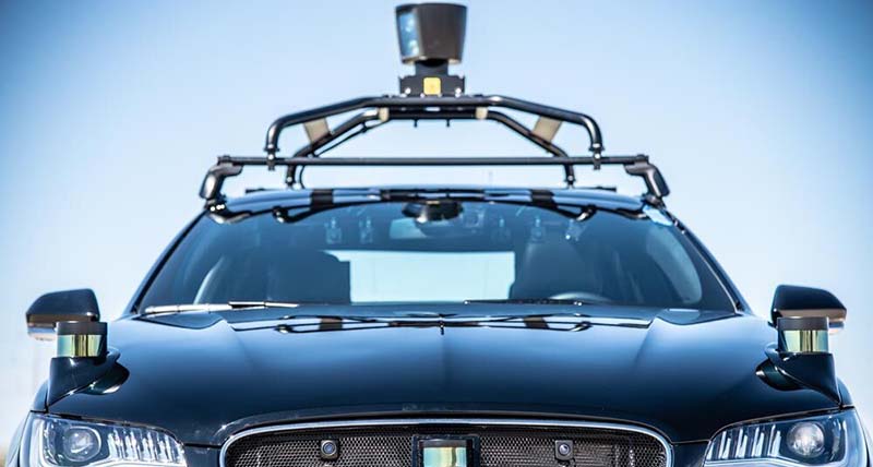 Close up of the front of a vehicle showing sensors on the roof and corners